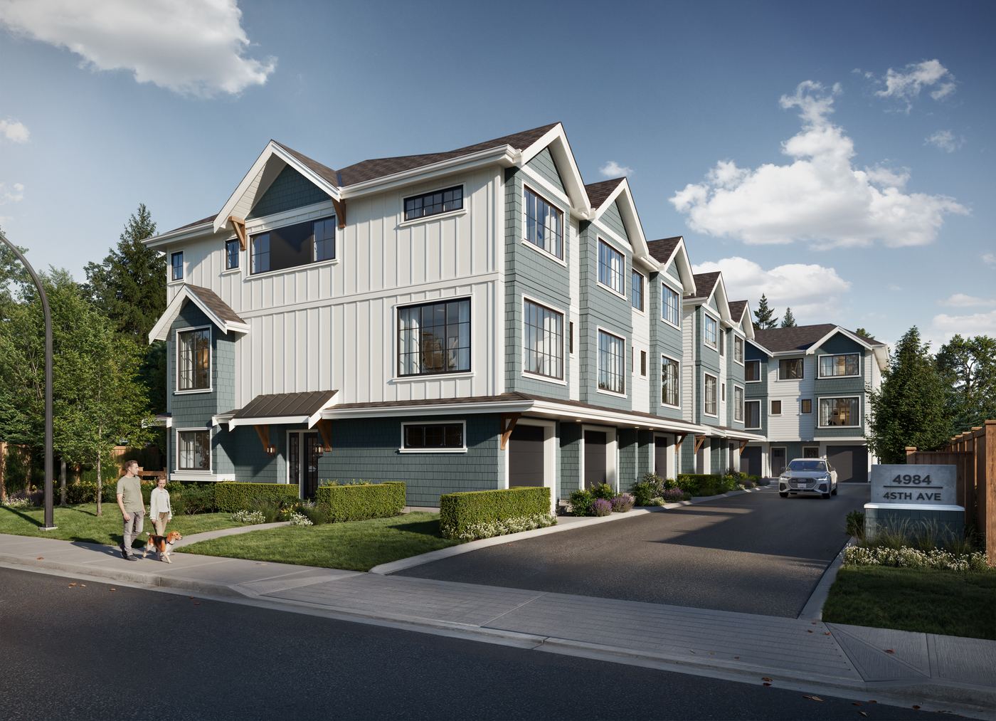 Street view of Shelby West: a row of three-storey townhomes with teal-green shingle siding, white board-and-batten trim, a dark shingle roof and black windows. Covered garages run along the driveway, clipped hedges and planting edge the front entries, two people walk a dog on the sidewalk, and a monument sign reads 4984 45th Ave.